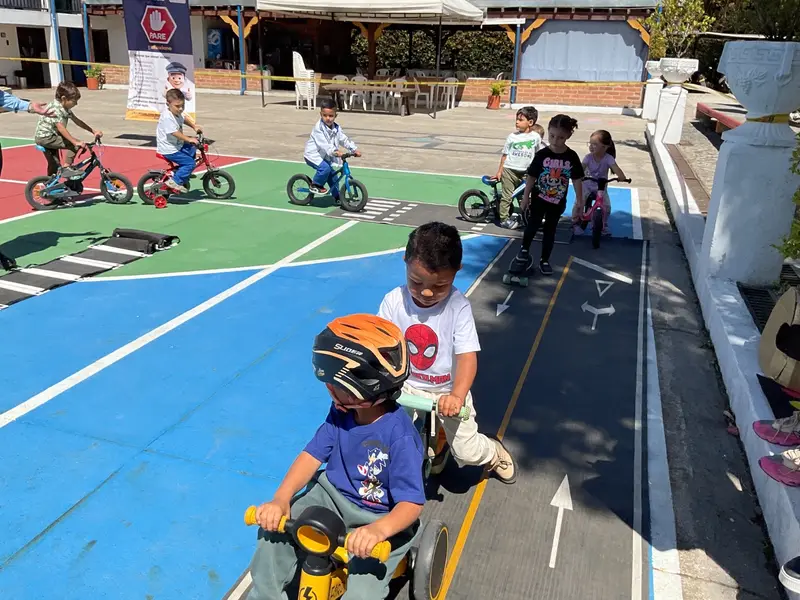 Niño de preescolar montando bicicleta en la pista de movilidad del colegio