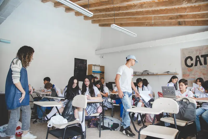 Aula de bachillerato del Colegio Anglo Español con estudiantes trabajando y su docente acompañando